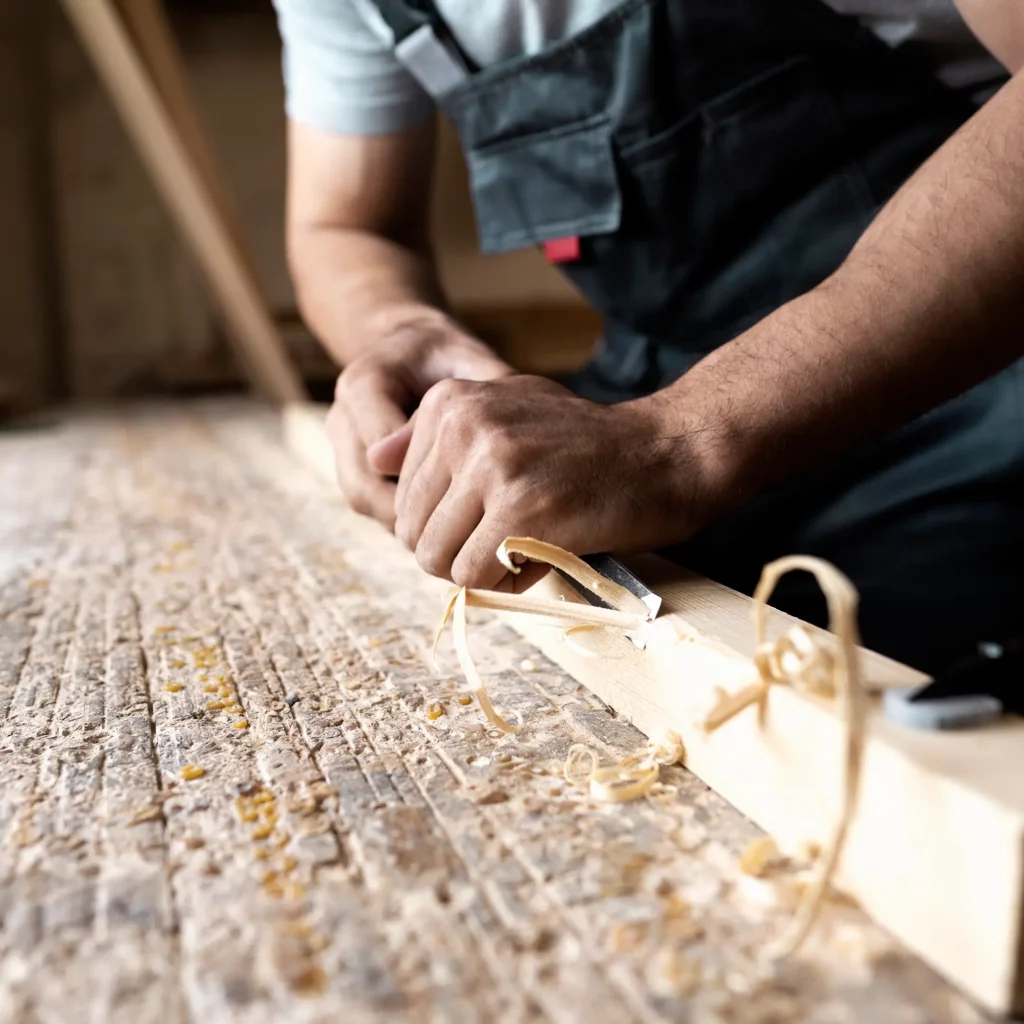 charpentier-coupant-le-panneau-de-forces-de-defense-principale-a-l-interieur-de-l-atelier2